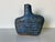 A striking handcrafted studio pottery vase featuring an organic, sculptural silhouette and a richly textured blue glaze....