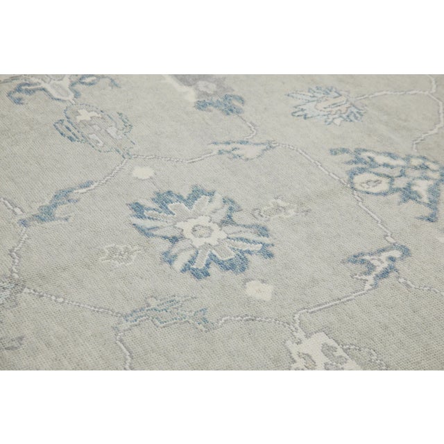 This modern Turkish Oushak rug is a stunning piece of art that has been handwoven using traditional techniques by skilled...