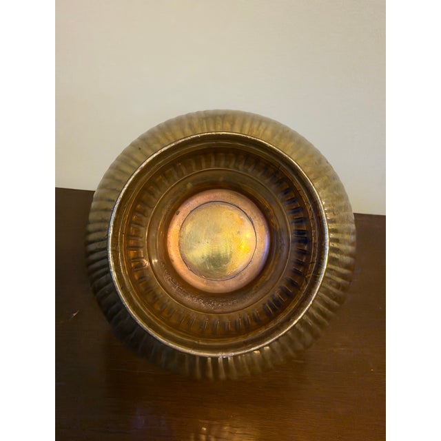 A charming vintage brass basket with a swing handle. The round bowl has a pierced lattice band around the rim above a...