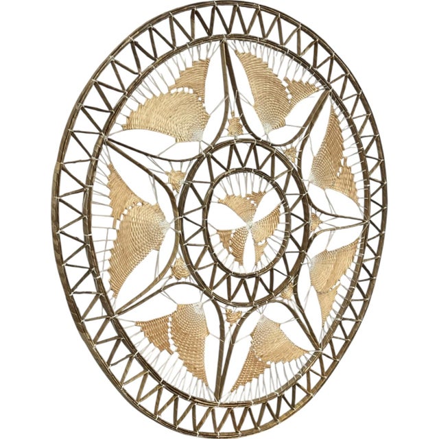 Decorative vintage round wall hanging featuring a handwoven natural fiber design.The openwork composition incorporates...