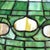 A vintage Tiffany style leaded stained glass table lamp, featuring a bronze-toned metal base and a vibrant green domed...