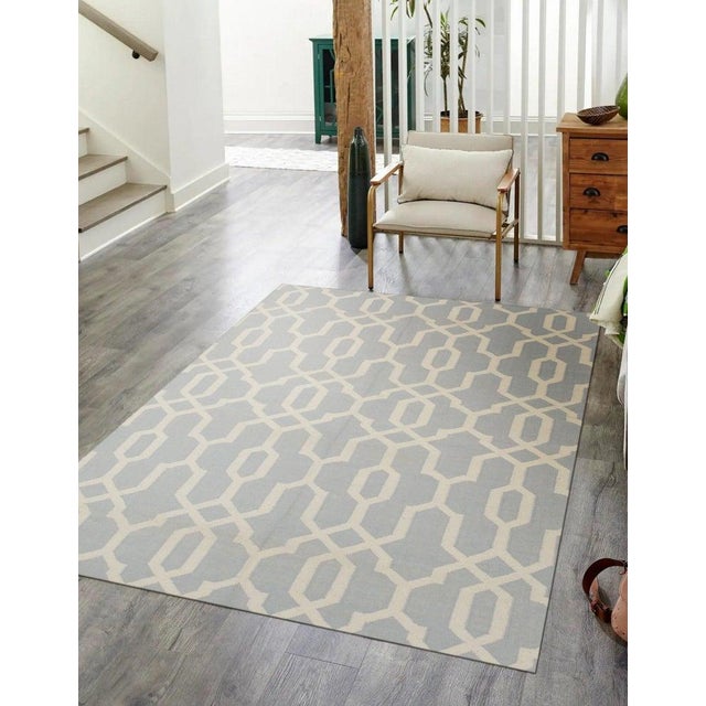 This blue wool rug features a flat weave construction typical of Kilim style floor coverings. Handcrafted in India, this...