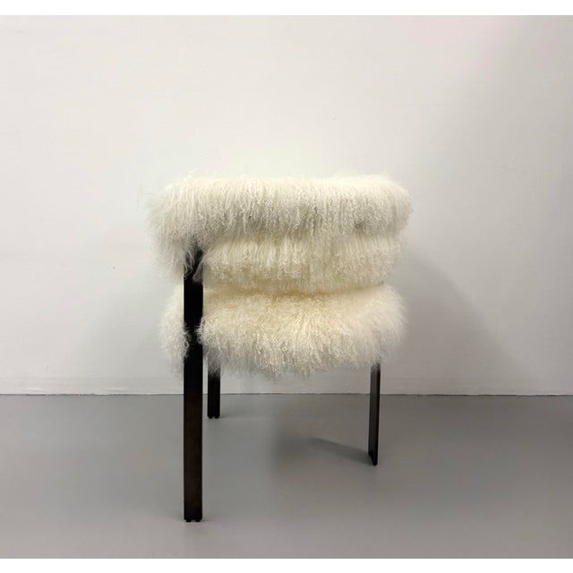 A chic pair of contemporary armchairs featuring plush ivory Mongolian lamb fur upholstery contrasted by slender black...