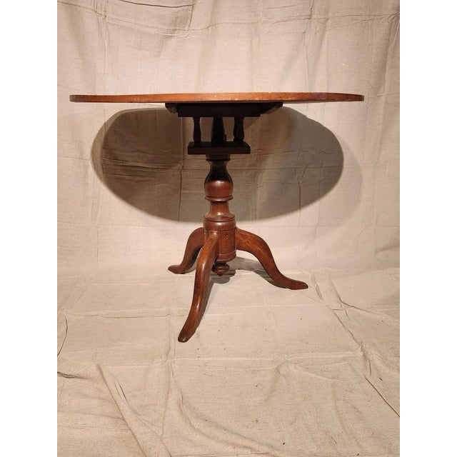 Beautiful round cherry table from the 18th century. It has a birdcage support for the tilt top and tripod base. It has...