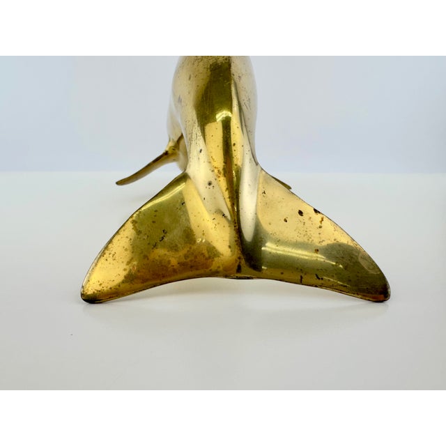 A vintage brass dolphin sculpture with a beautifully streamlined form and warm, naturally aged patina. The sculptural body...