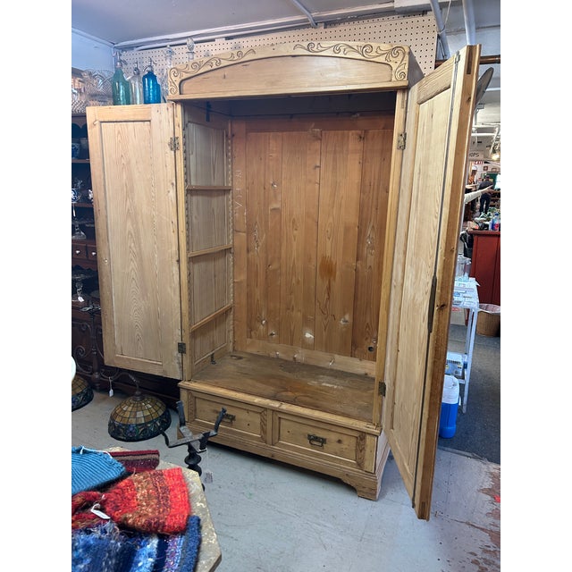 Charming natural Irish pine armoire having panel doors that open to reveal 21 d x 62 h interior with wooden slats for...