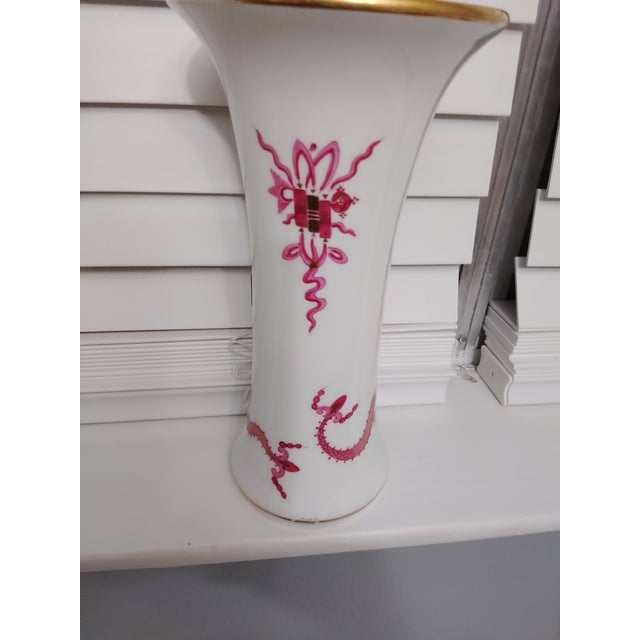 The Meissen vase has a gold rim with purple dragon decor on white porcelain with a gold rim.