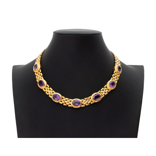 18K Yellow Gold and Amethyst Necklace, featuring seven bezel set oval brilliant amethysts weighing a total of approx....