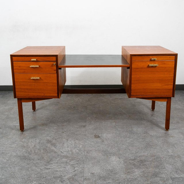 Teak executive desk with brass handles, 5 drawers including file cabinets and storage. Comes with unique black central...