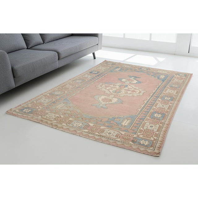 Elevate your living space with this exquisite, hand-knotted vintage Turkish rug. Featuring a sophisticated and calming...