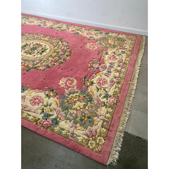 Beautiful large hand knotted rug from Cambodia featuring an elegant floral medallion design. The soft pink field is richly...