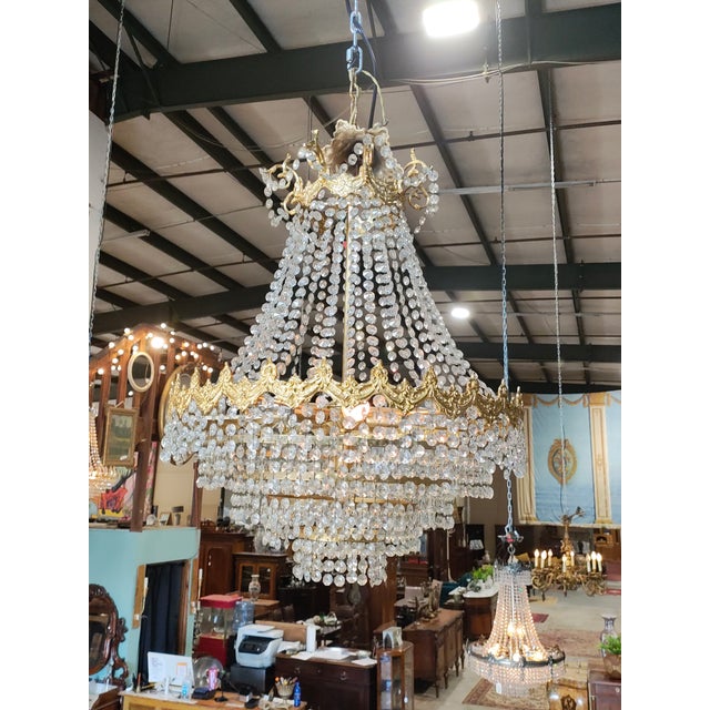 A beautifully detailed French Empire style crystal basket chandelier featuring cascading strands of faceted octagonal...
