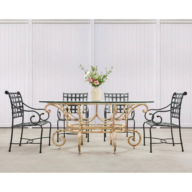 A monumental 20th century oval glass top and wrought iron garden or patio dining table crafted in an Italian Regency...