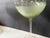 These sculptural stemware pieces showcase a soft transition from clear to olive green, enhanced by vertical optic ribbing...