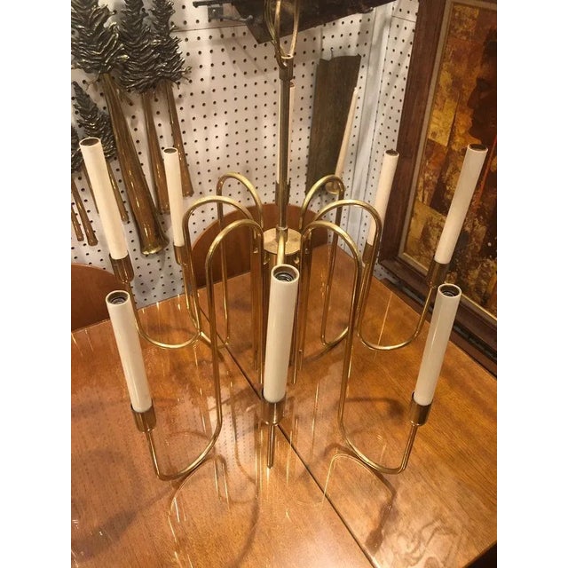 Mid-Century Modern brass chandelier attributed to Tommi Parzinger for Lightolier. Eight delicate brass arm chandelier with...