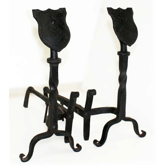 Antique early 20th century wrought iron andirons Shield form finials on twist and scroll supports. Circa 1905.