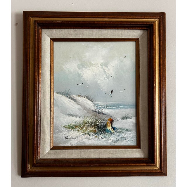 Vintage 1970’s seascape painting on wood panel of a girl sitting on the beach with seagulls. Signed to the lower left...