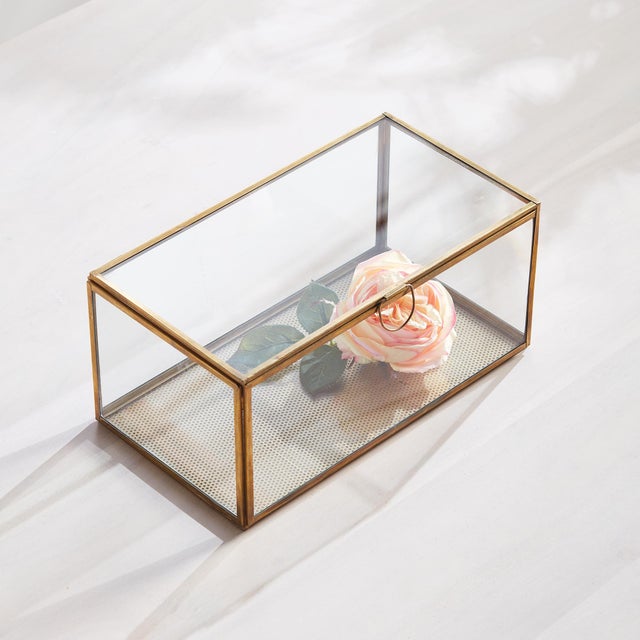 Simple and tailored, this glass and brass box is made to hold your most treasured mementos. A delicate loop handle keeps...