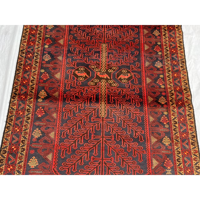 An exceptional vintage Afghan Baluchi rug featuring a symbolic Tree of Life design, hand-knotted with remarkable precision...