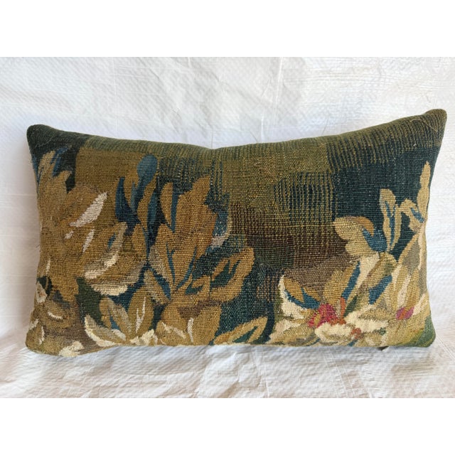 Exceptional 17th century Flemish tapestry pillow featuring a richly woven verdure inspired floral composition in muted...