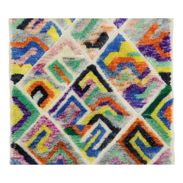 This hand-knotted wool runner rug by Azele Studio features a vibrant geometric composition with an intricate diamond and...