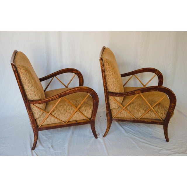 An unusually beautiful pair of vintage lounge chairs from Italy. Made of solid wood with an upholstered seat and back. A...