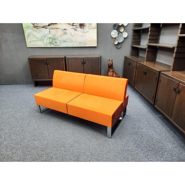 A wonderful sofa from Martin Stoll. Great color combination of orange and brown. The sofa rests on solid chrome sled-style...