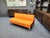 A wonderful sofa from Martin Stoll. Great color combination of orange and brown. The sofa rests on solid chrome sled-style...