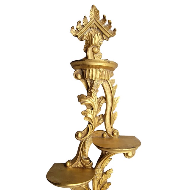 An unusually large vintage Italian carved giltwood wall shelf featuring five graduated display platforms incorporated into...
