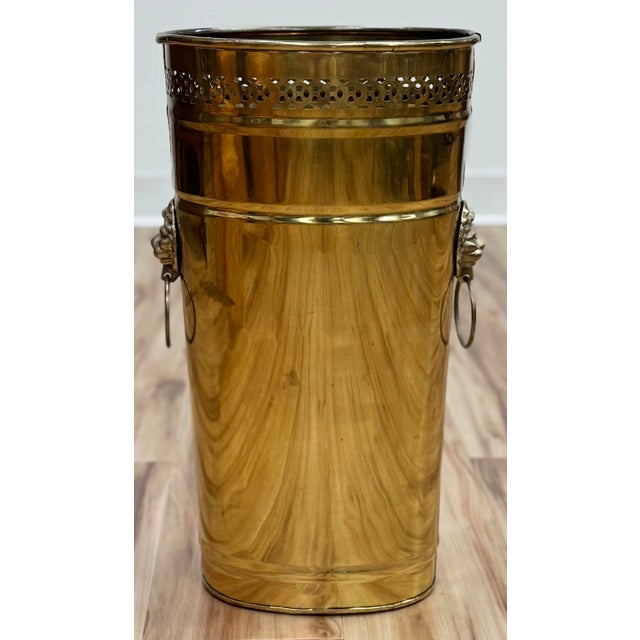 Vintage pierced brass umbrella stand or waste bin. Features lion head ringed handles to either side. Clean exterior and...