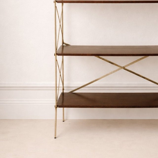 Wooden shelving unit with a lightweight design and cross-bracing structure. This elegant mid-century modern shelving unit...