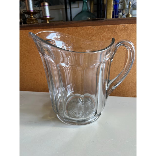 Vintage heavy glass pitcher from the Early 20th Century. Could be used as a flower vase or beverage pitcher. Measuring 9”...