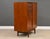 A mid century modern teak armoire dresser with a vanity mirror and a rod for hanging clothes. Made in Denmark. Circa...