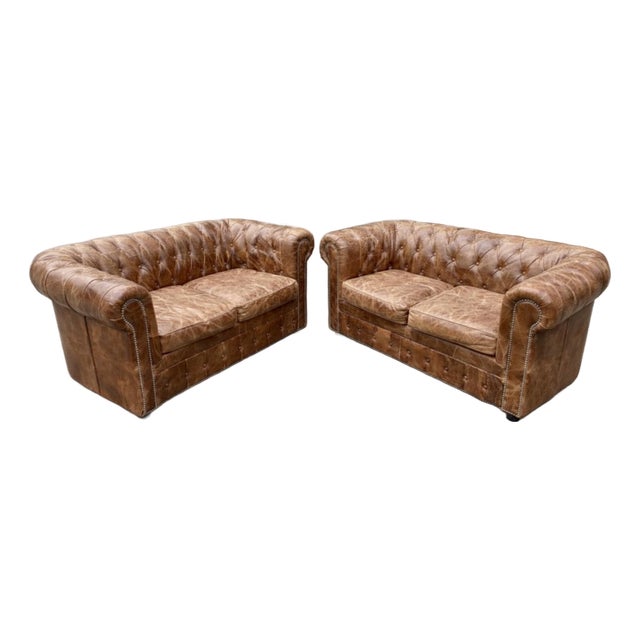 Fabulous pair of French leather Chesterfield sofas. You will love the worn patina on these light brown tufted sofas which...
