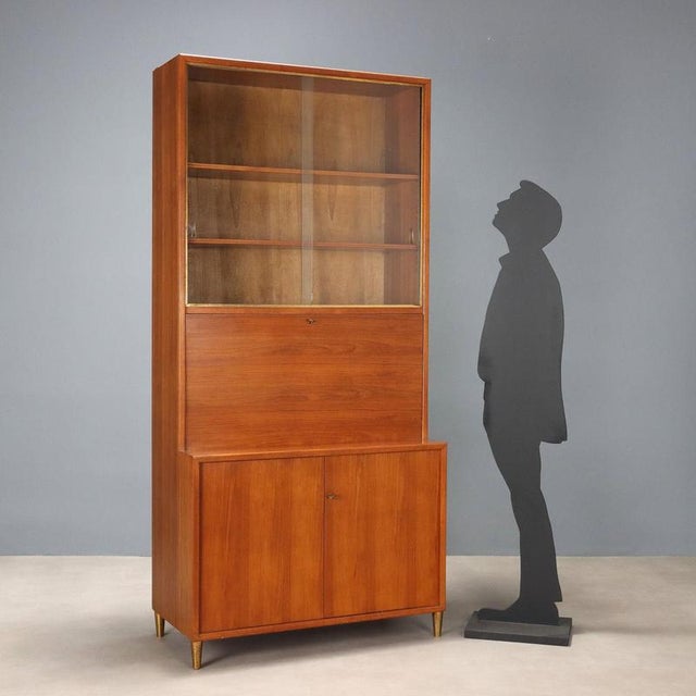 Larch veneered storage unit with brass accents, featuring a display case, drop-down door, and hinged doors. In good...