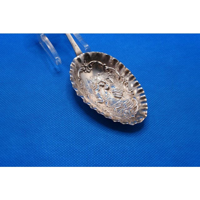 This marvelous tea caddy spoon is created in gorgeous German Hanau silver and the subject is a man and woman dancing, a...