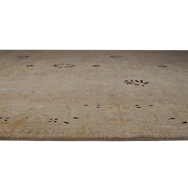 A hand-knotted wool rug, made in India and measuring 8' x 9'9"'. Floral drawing carried across the field inside a...