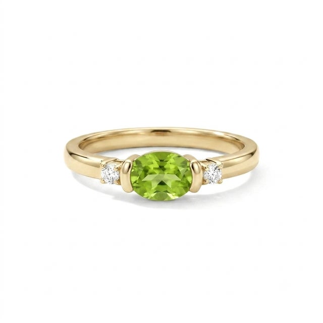 Sophisticated, contemporary, and beautifully minimalist. This exquisite three-stone ring features a stunning 6x4mm oval-...