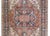 A bold early 20th century Persian Heriz rug with a traditional large central floral patterned medallion woven in myriad...