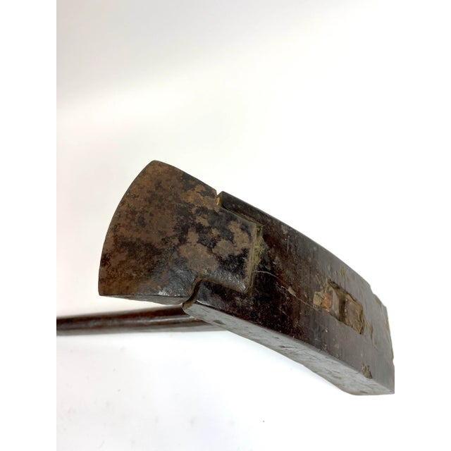 A iron and wood rustic farming tool from 19th century China. The top is designed where the iron piece can be replaced on...