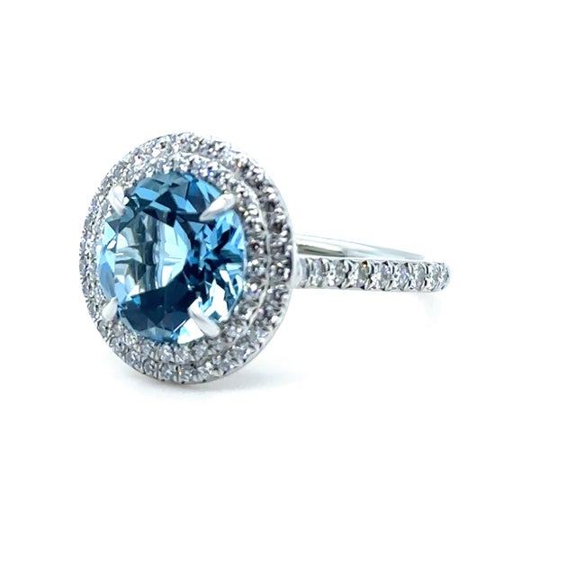 A timeless Tiffany & Co. Soleste ring crafted in platinum, featuring an impressive aquamarine centre stone surrounded by a...