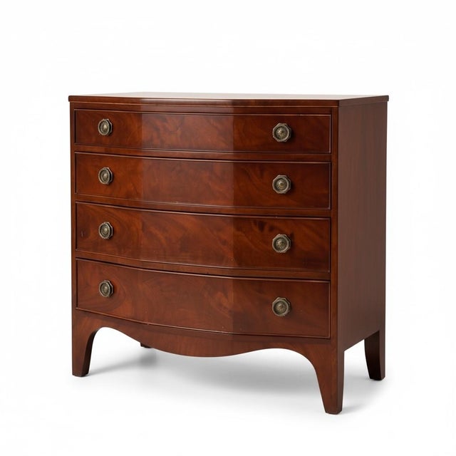 This is a pair of Federal style flame mahogany modified bowfront chests by New York manufacturer, Nahon Furniture Company....