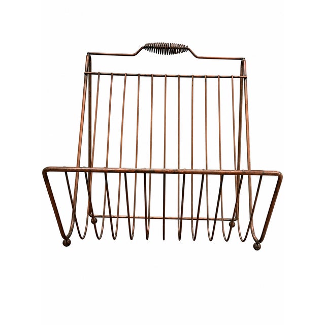 Charming vintage wire magazine rack featuring an airy, sculptural openwork design. Constructed from slender metal rods,...