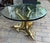 "Three dolphins coffee table" coffee table 20 mm thick glass top supported by three brass dolphins on a triangular support...