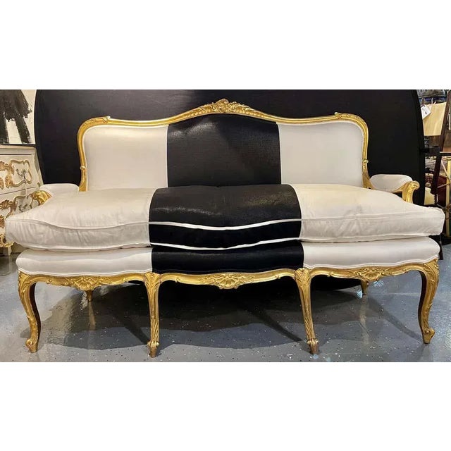 1930s French gilt wood upholstered settee, canape or sofa in black and white polished cotton. One of a compatible pair of...