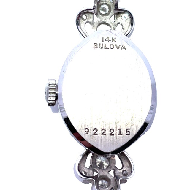 Vintage Bulova ladies wristwatch crafted in solid 14k white gold, featuring an elegant oval dial framed by a diamond-set...