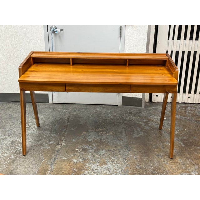 Design Plus Gallery presents a Drommen Acacia Wood Desk from CB2. Defined by its angled legs, integrated raised back...