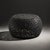 Black fiber openwork coffee table with a sculptural rounded form and intricate cutout pattern across the entire body. The...