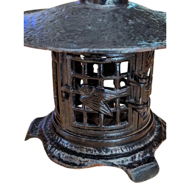 This vintage cast iron pagoda lantern features a broad sculptural roof, openwork lattice panels, and a decorative bird...