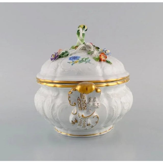 Meissen porcelain lidded tureen with hand-painted flowers and gold edge. Lid modelled with flowers and foliage. 1920s....